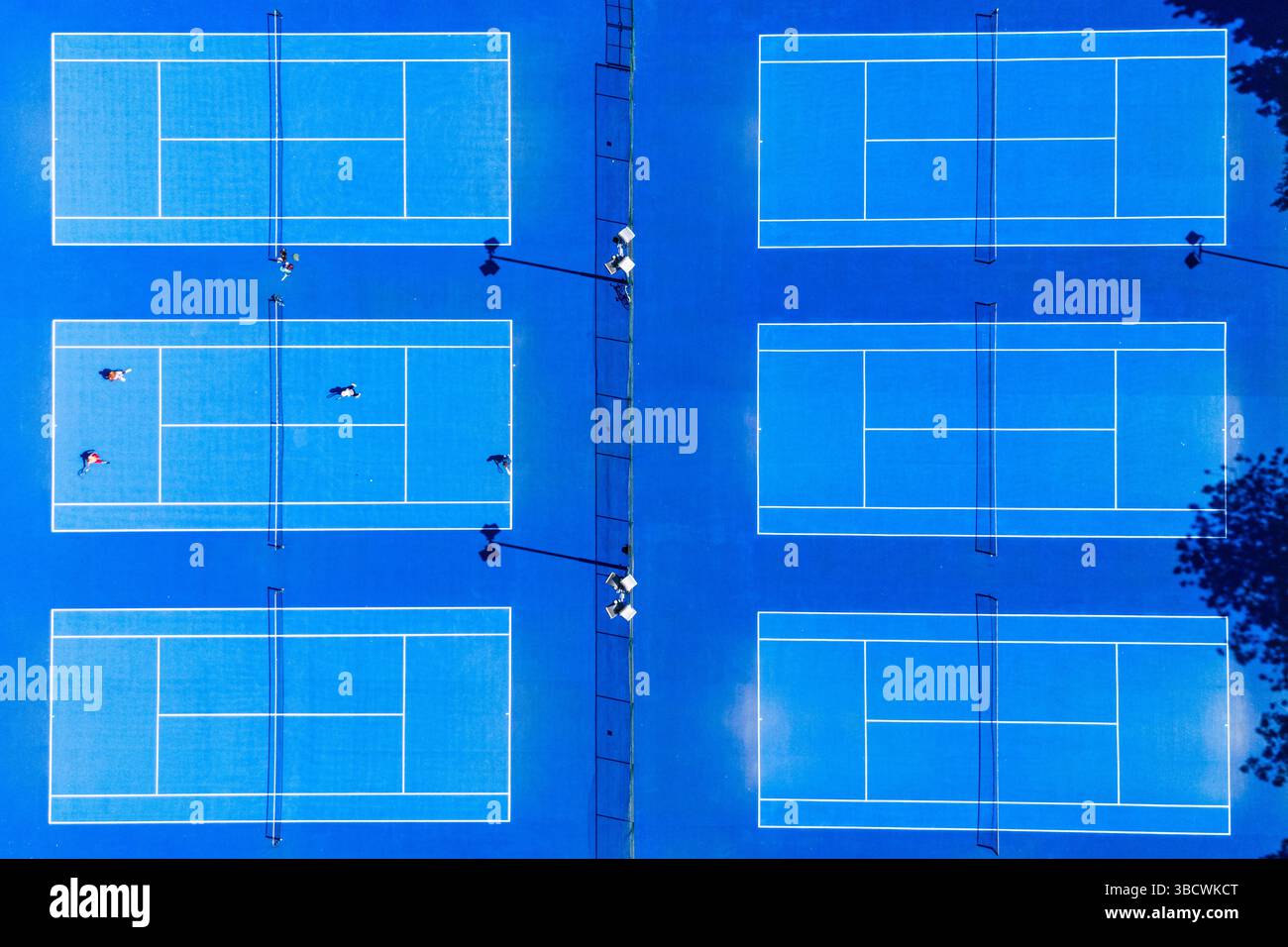 Quatre personnes ont été vues jouer une partie de double sous le soleil d'été sur les courts de tennis de Wythenshawe Park, vus près de Manchester le 21 mai 2025. Banque D'Images