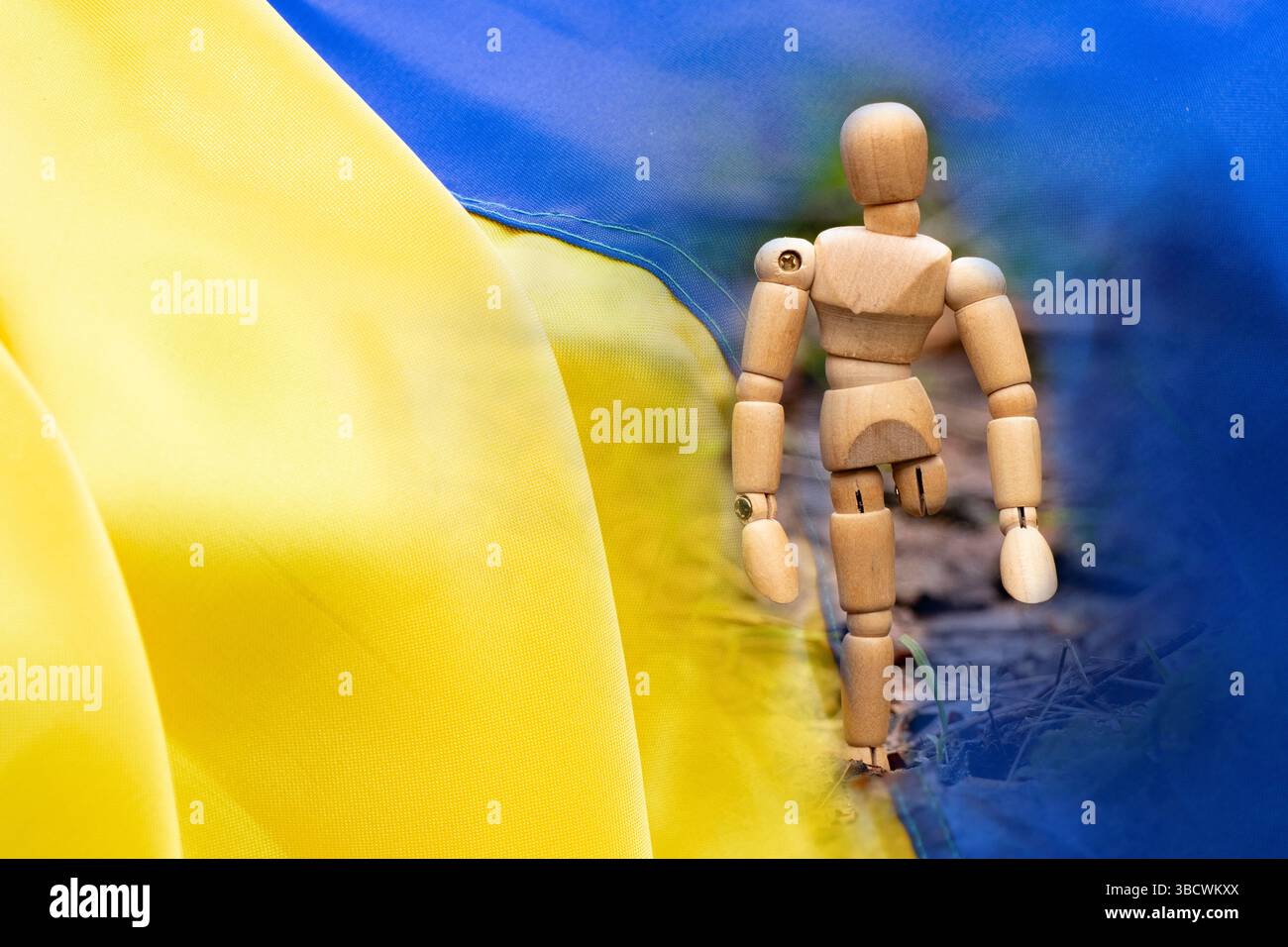 Poupée en bois sans jambe sur le fond du drapeau de l'Ukraine, personne handicapée et prothèses Banque D'Images