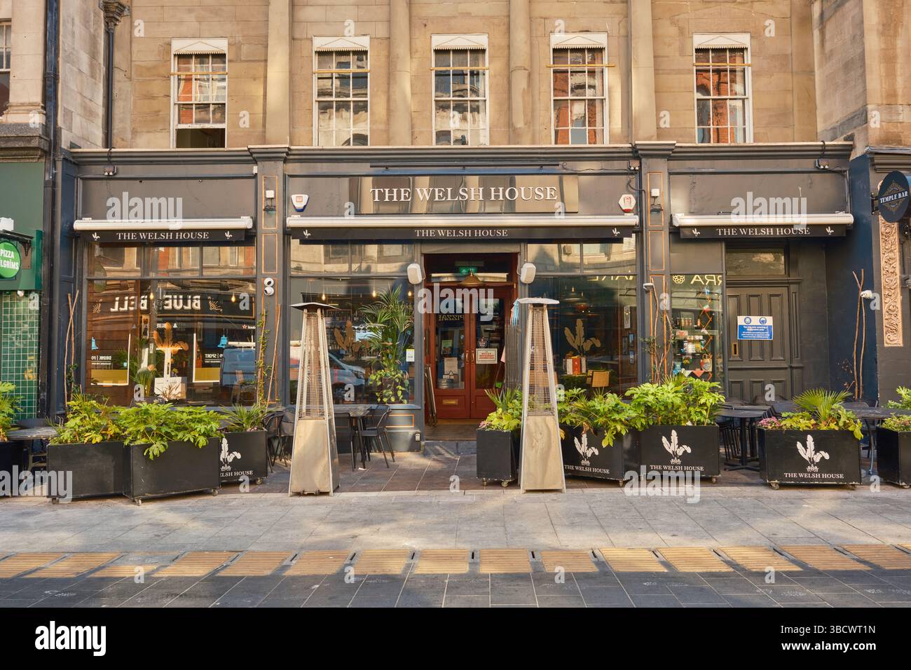 Vue de face de la Welsh House, un bar et restaurant dans le centre-ville de Cardiff, avec des plantes et des sièges en plein air par une journée ensoleillée, vu de la rue. Banque D'Images