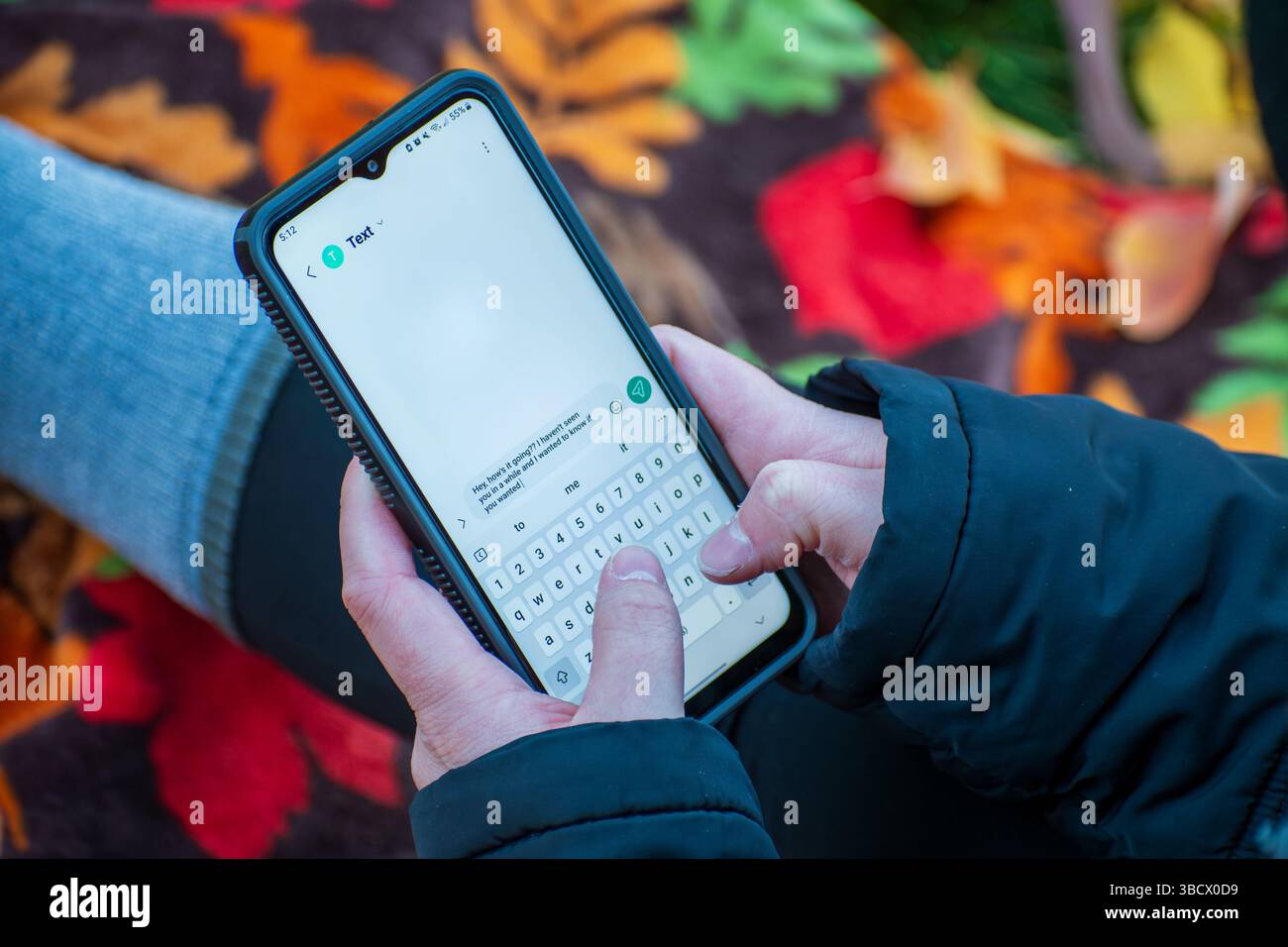 Salt Lake City, UT, États-Unis – 18 mai 2025 : une femme tient un smartphone, concentrée sur l'envoi d'un message texte, capturant la communication moderne en action. Banque D'Images