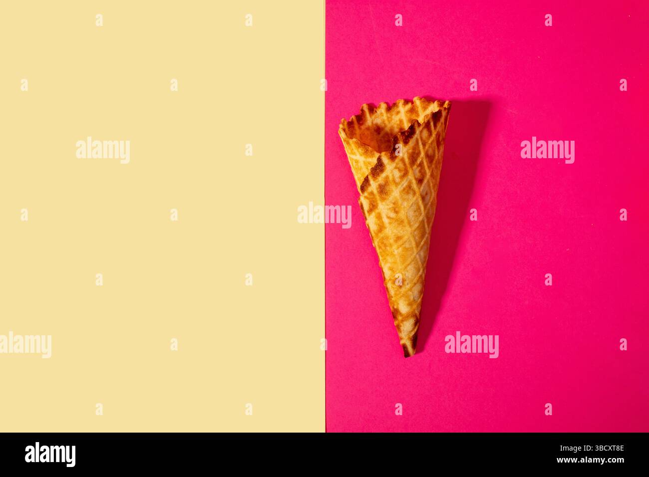 Cône de crème glacée sur fond rose et beige. Concept estival minimal. Pose à plat. Banque D'Images