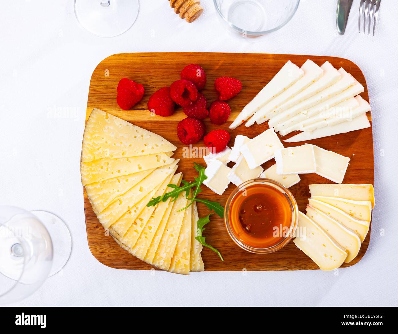 Différents types de fromage tranchés et servis sur une planche en bois Banque D'Images
