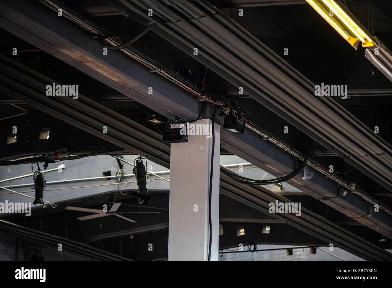 Une vue détaillée du câblage et des connexions d'un système électronique installés directement sur un plafond en béton brut dans un cadre architectural moderne. Banque D'Images