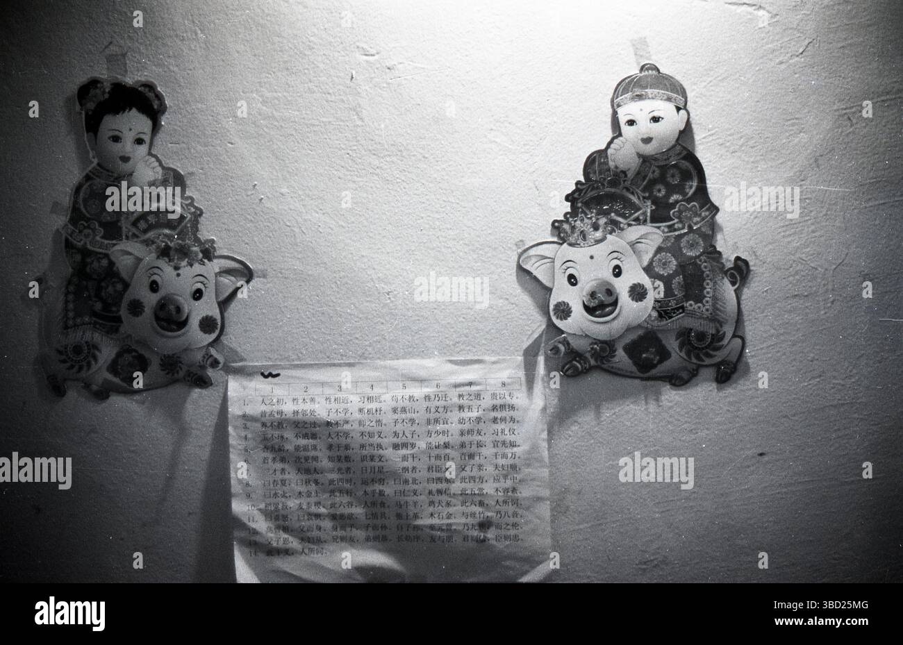 2007 film noir et blanc Portrait d'or Boy Jade Girl Prints et San Zi Jing ( classique à trois caractères ) dans une maison chinoise, Zhejiang, Chine Banque D'Images