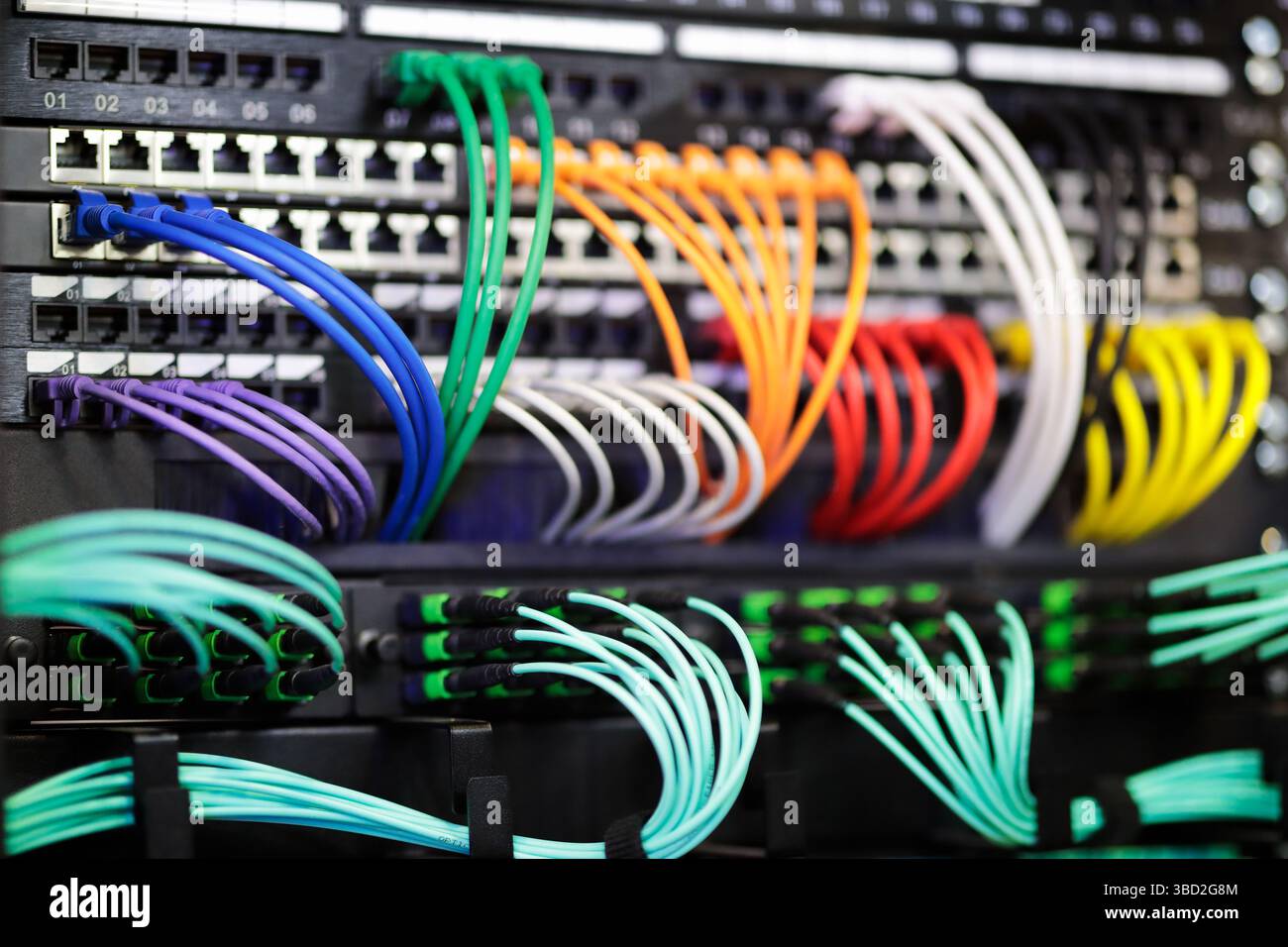 Équipement de mise en réseau de commutation moderne dans des racks de serveurs avec câbles ethernet et fibre optique. Mise au point sélective. Banque D'Images