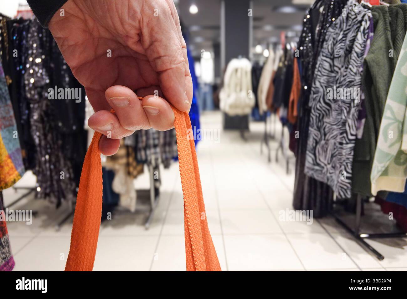 Sac à provisions hilding de main masculine dans le magasin de vêtements de détail Banque D'Images