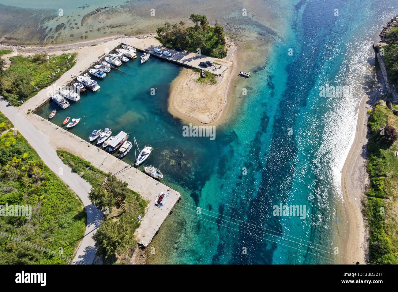 Vue aérienne d'un petit port de plaisance à l'entrée du canal de Nea Potidea à Halkidiki, Grèce, avec des eaux turquoises, des rives sablonneuses et des bateaux ancrés Banque D'Images