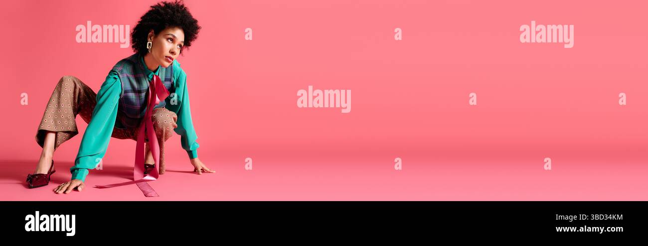 Dans une pose artistique, une jeune belle femme met en valeur son sens de la mode avec une tenue colorée. Banque D'Images