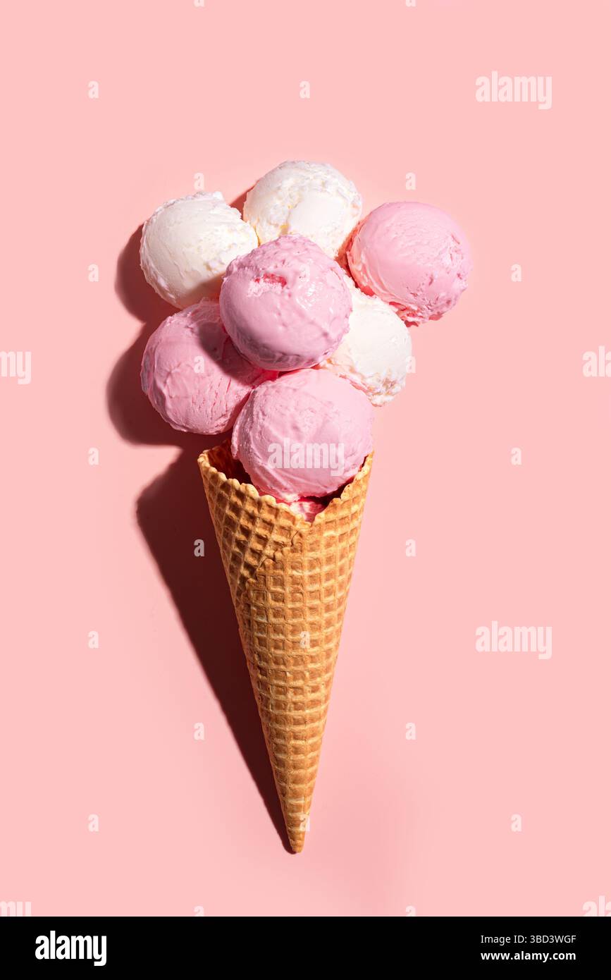 Cône de crème glacée avec des cuillères à fraise et vanille sur fond pastel rose, pose plate créative, espace de copie. De nombreuses cuillères à crème glacée bio délicieuses dedans Banque D'Images