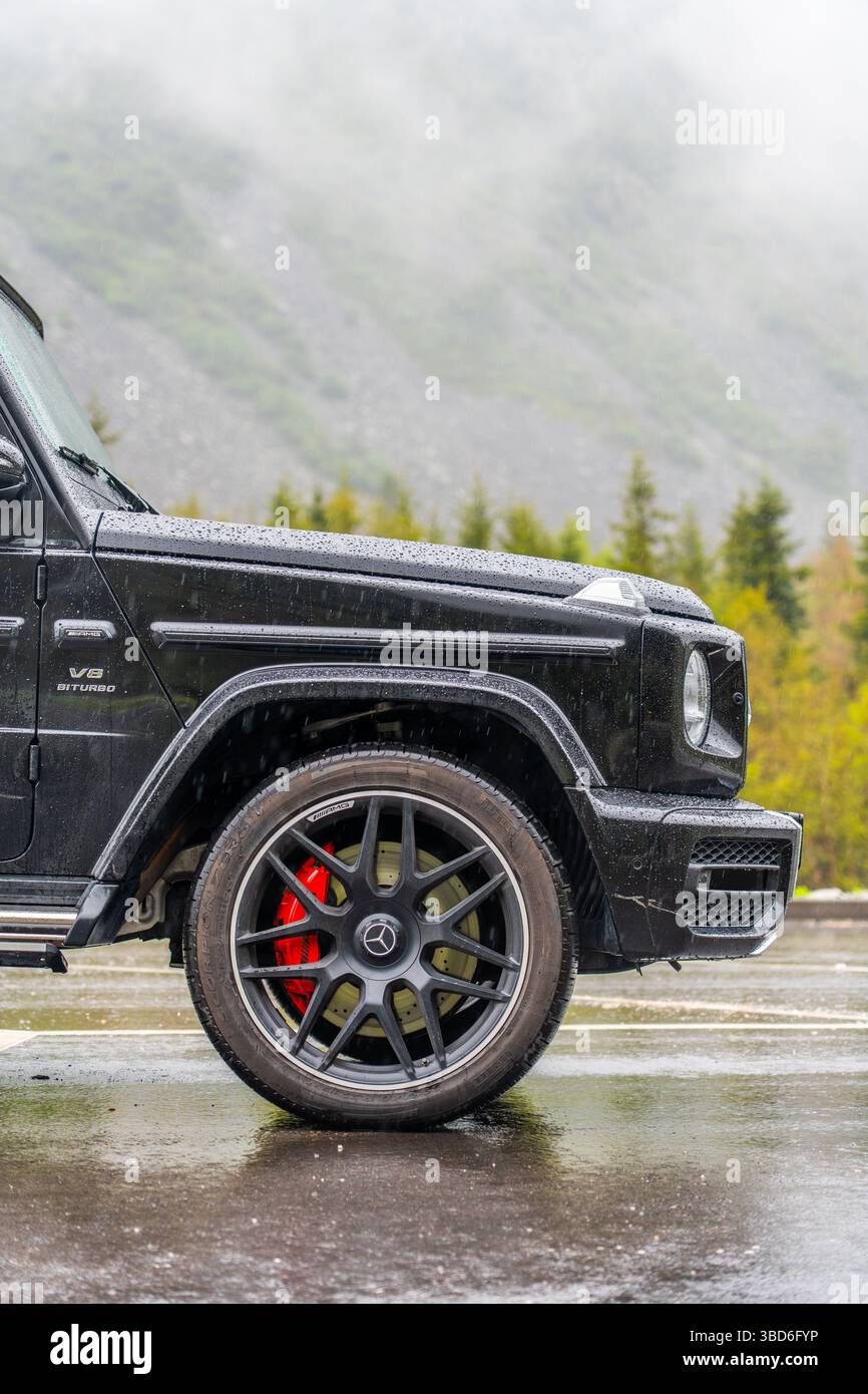 Bichkek, Kirghizistan - 12 mai 2024 : gros plan d'une roue Mercedes classe G noire mouillée avec étriers de frein rouges Banque D'Images