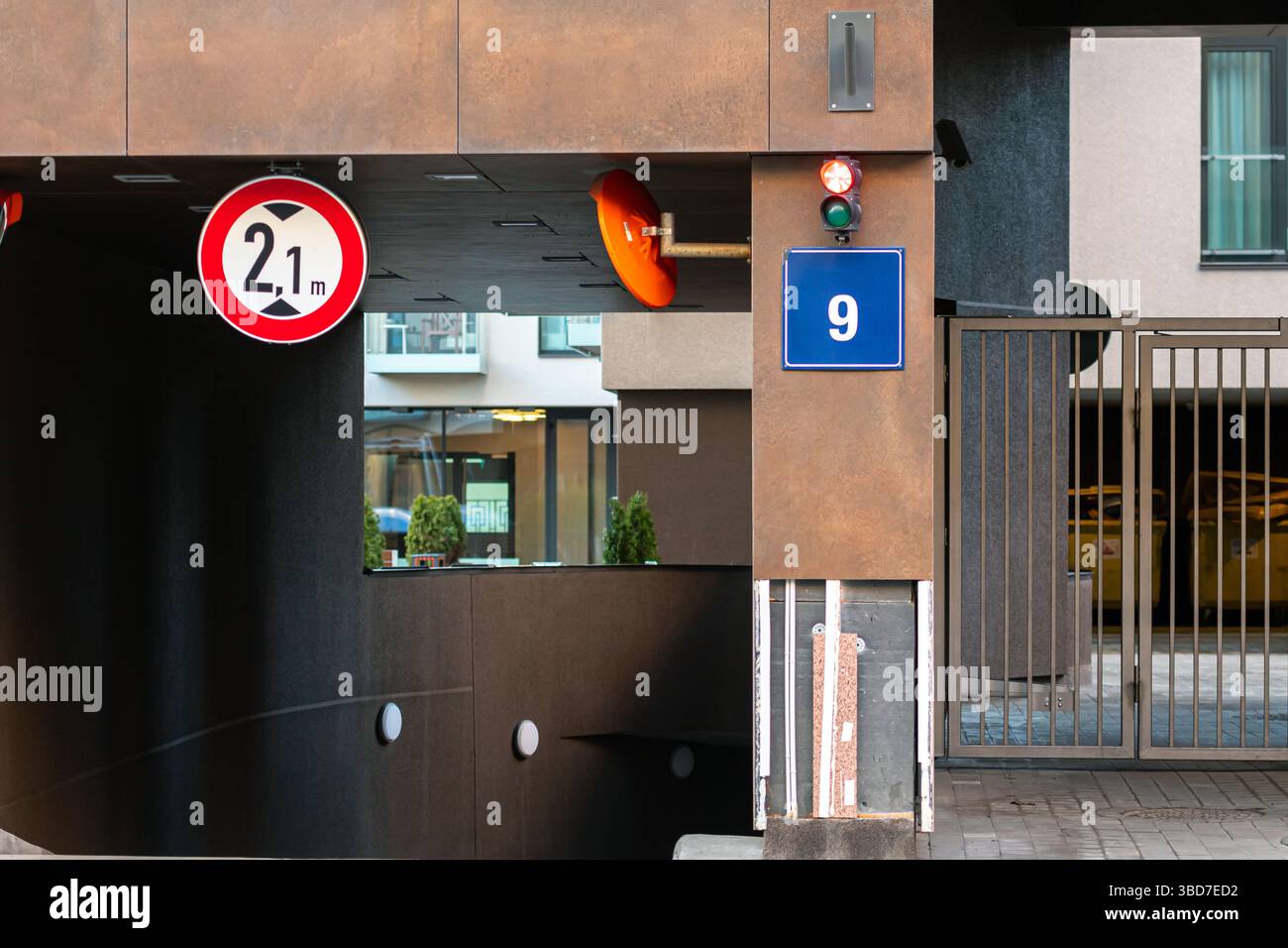 Les voitures approchent d'un garage avec un panneau de limite de hauteur et une entrée fermée dans la ville. Banque D'Images