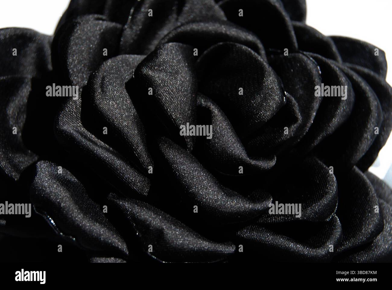 Rose noire placée artistiquement sur fond d'écriture arabe foncé. Banque D'Images