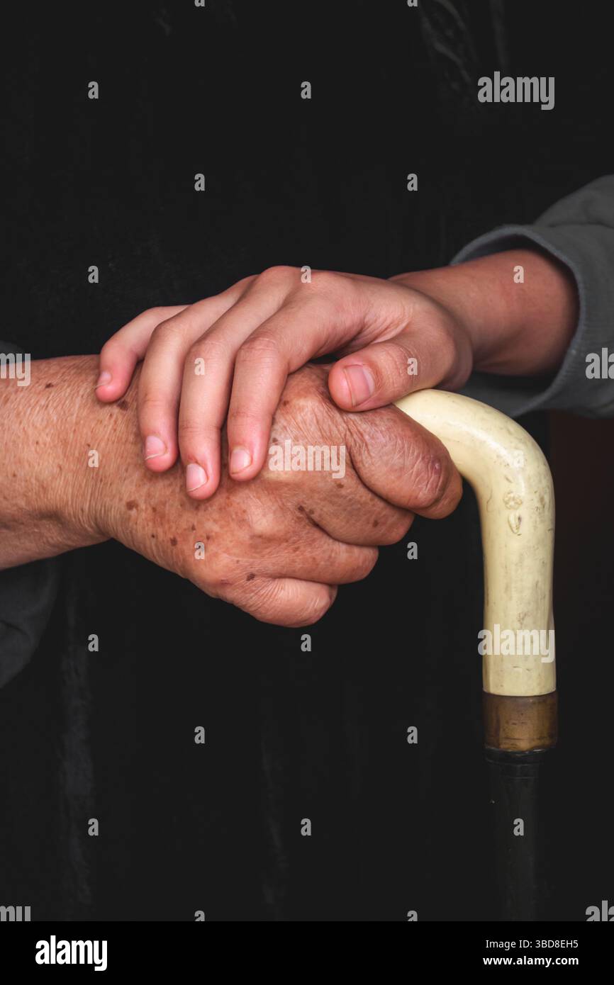 Lien générationnel – petit-enfant tenant les mains des grands-parents Banque D'Images
