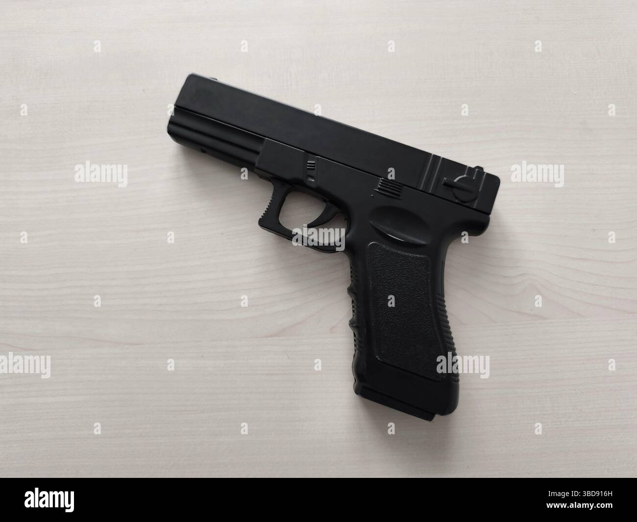 Un briquet qui ressemble à un pistolet sur fond de bois Banque D'Images