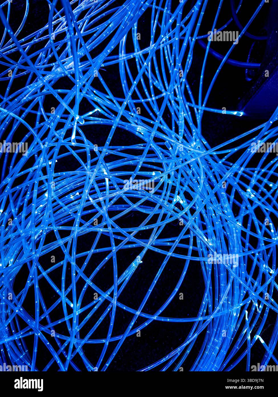 Arrangement abstrait de lumières LED bleues allumées ou allumées sur des fils enroulés sur un fond noir - Image de stock capturée avec un smartphone