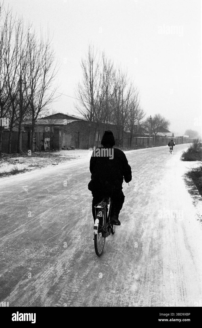 Cycliste sur Icy Suburban Road au début des années 2010 en Chine Banque D'Images