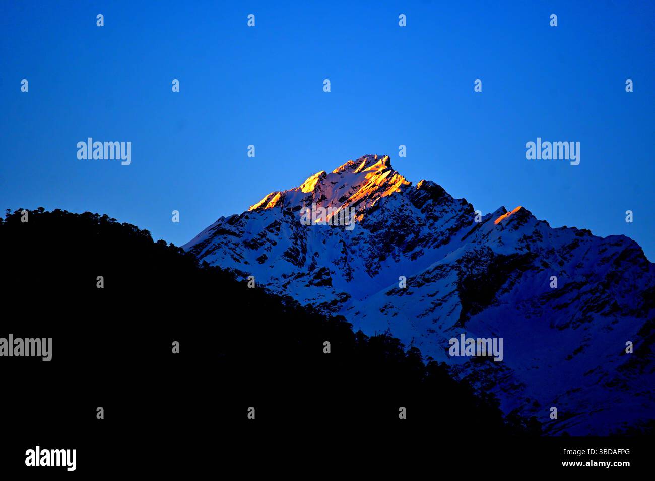 Rayons de soleil frappant un sommet de montagne à l'aube dans la vallée de Lachung, Sikkim Banque D'Images