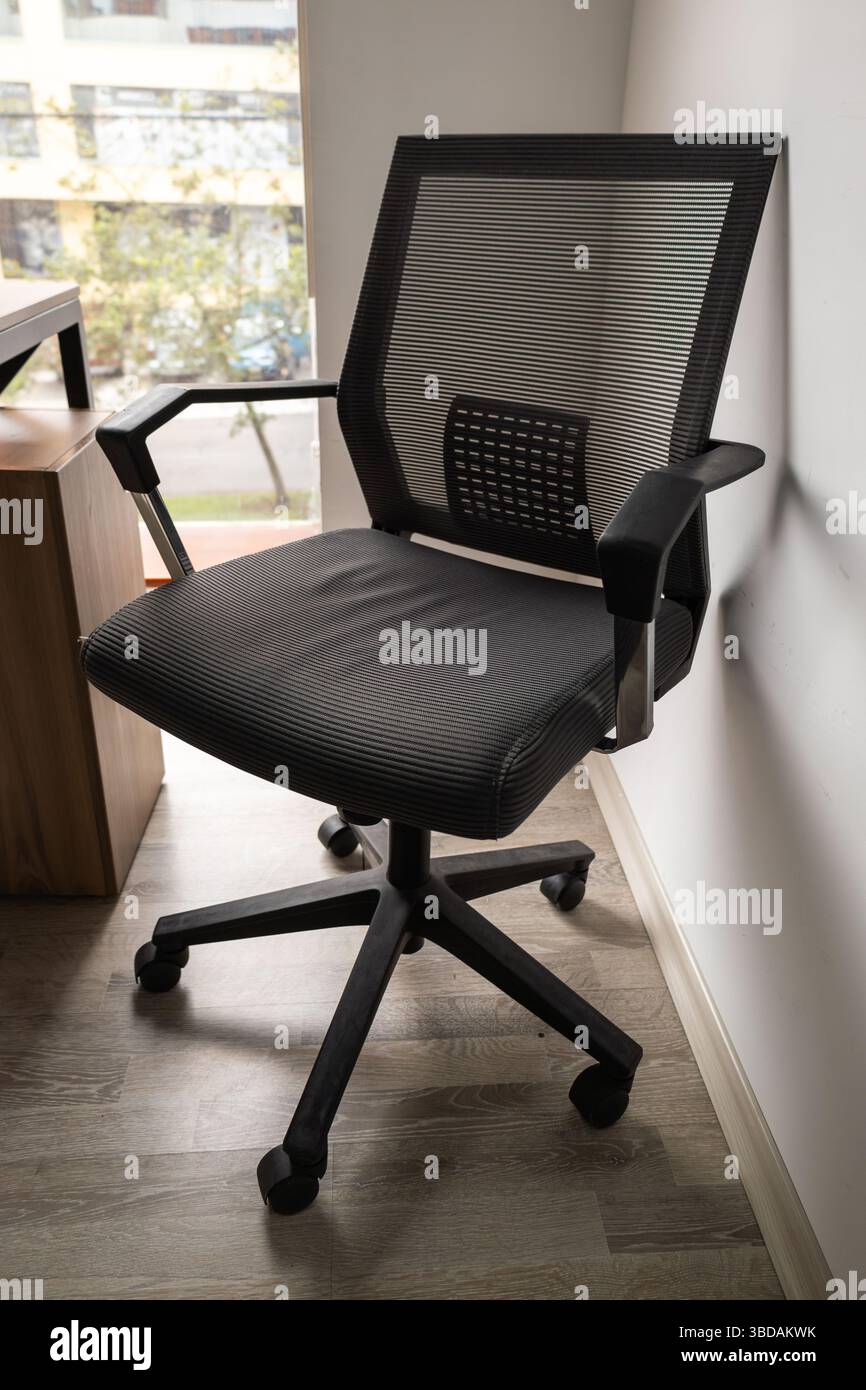 Une chaise de bureau noire moderne au design ergonomique, offrant confort et style pour les espaces de travail professionnels et les bureaux à domicile. Banque D'Images
