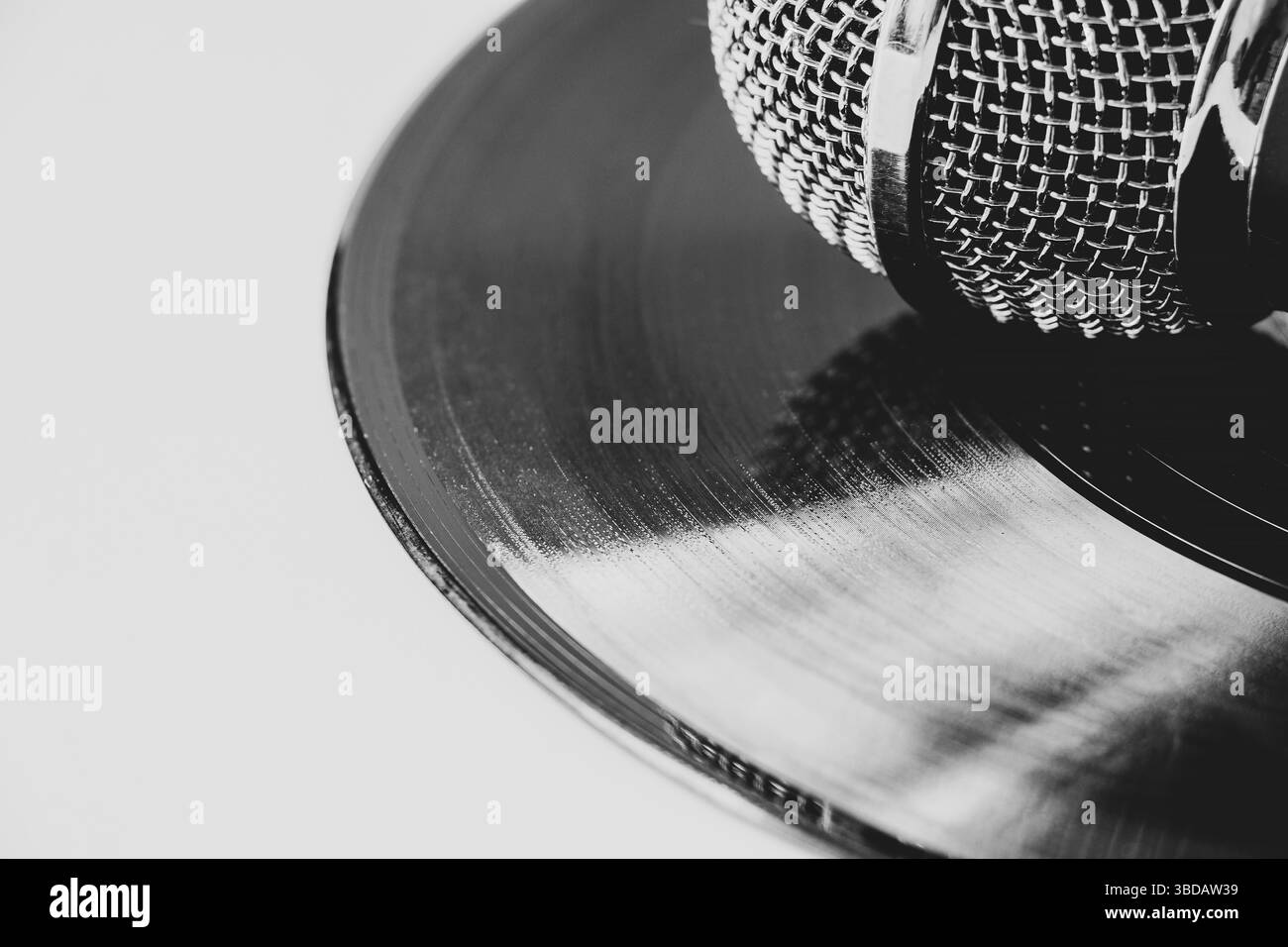 Photo noir et blanc du microphone sur disque vinyle sur fond blanc. musique et son rétro Banque D'Images