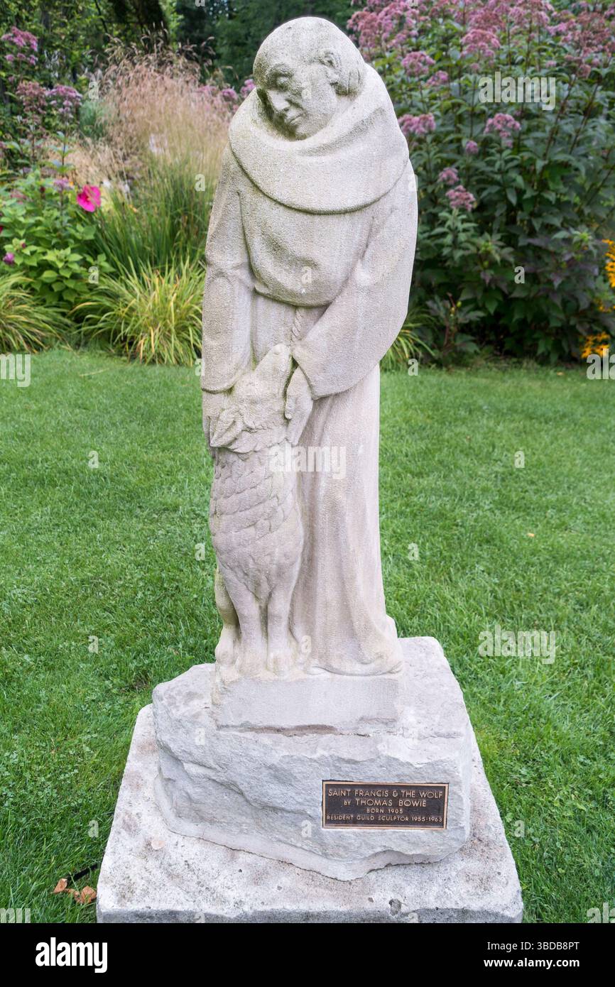 Une figure en pierre sculptée de « préparation Francis and the Wolf », l'animal vicieux légendaire qu'il est connu pour avoir apprivoisé. Le Guild Inn Toronto Ontario Canada Banque D'Images