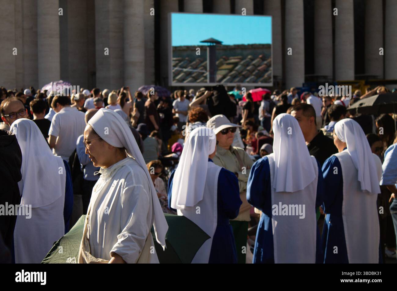 La place Pierre à la Cité du Vatican bondée pendant le Conclave (2025), les religieuses au premier plan, les gens attendent la fumée blanche et le nouveau pape Léon XIV sur grand écran. Banque D'Images La place Pierre à la Cité du Vatican bondée pendant le Conclave (2025), les religieuses au premier plan, les gens attendent la fumée blanche et le nouveau pape Léon XIV sur grand écran. Banque D'Images