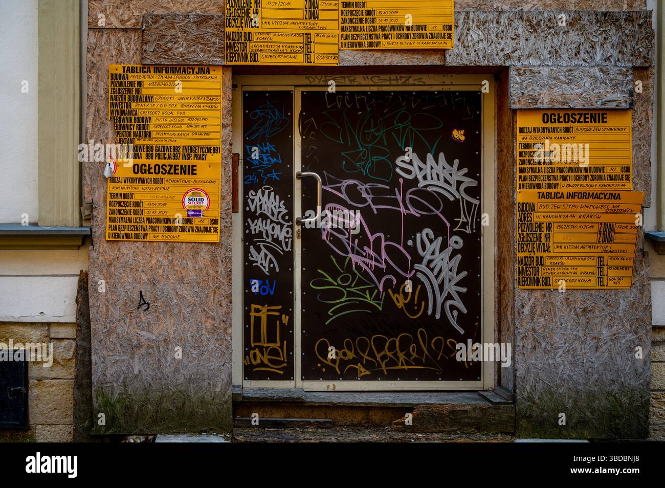 Porte couverte de graffitis et panneaux de construction à Kraków, Pologne Banque D'Images
