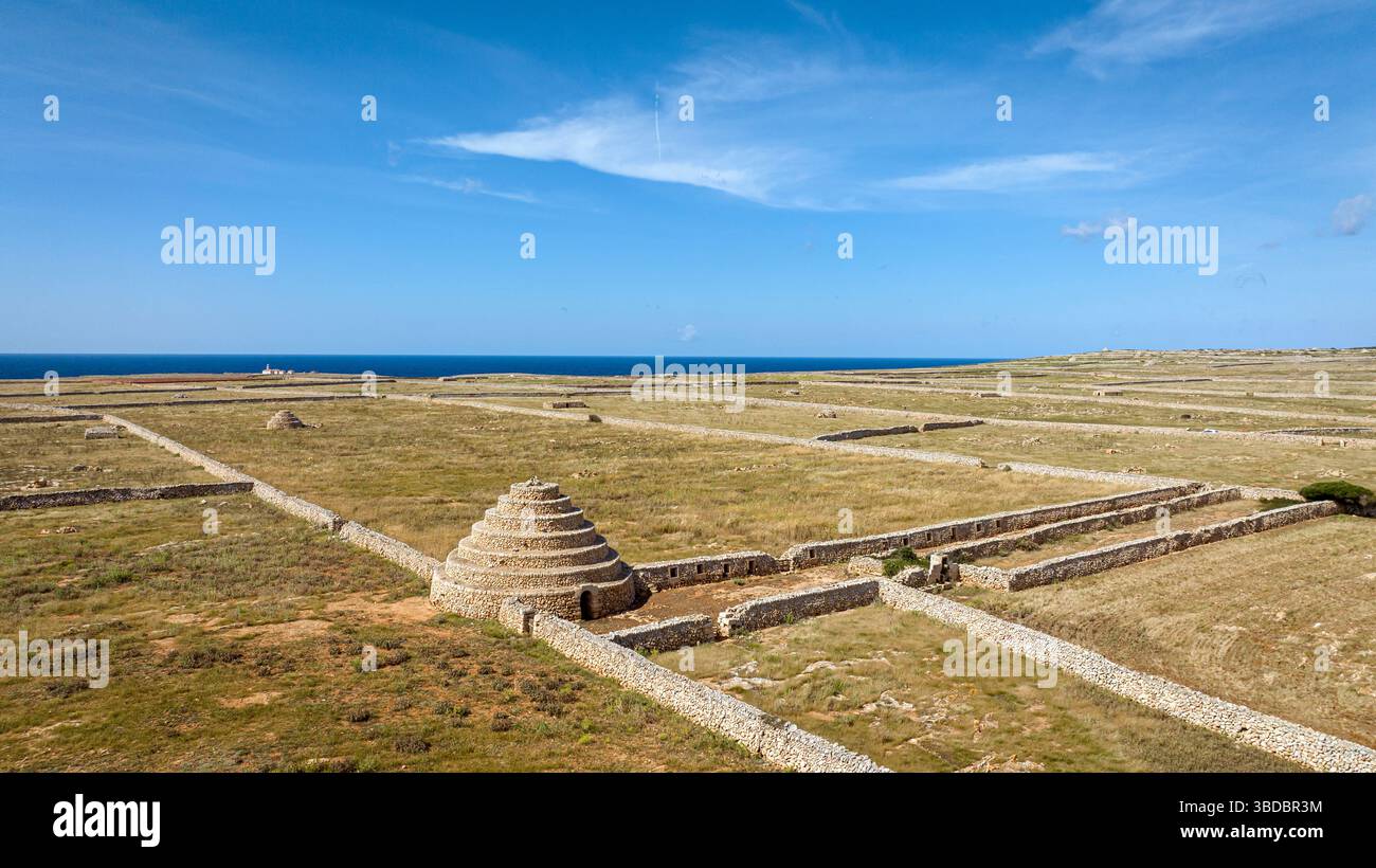 Étrange tour de pierre et murs de pierre le long du sentier de randonnée Camí de Cavalls à Punta Nati, Minorque, Espagne Banque D'Images