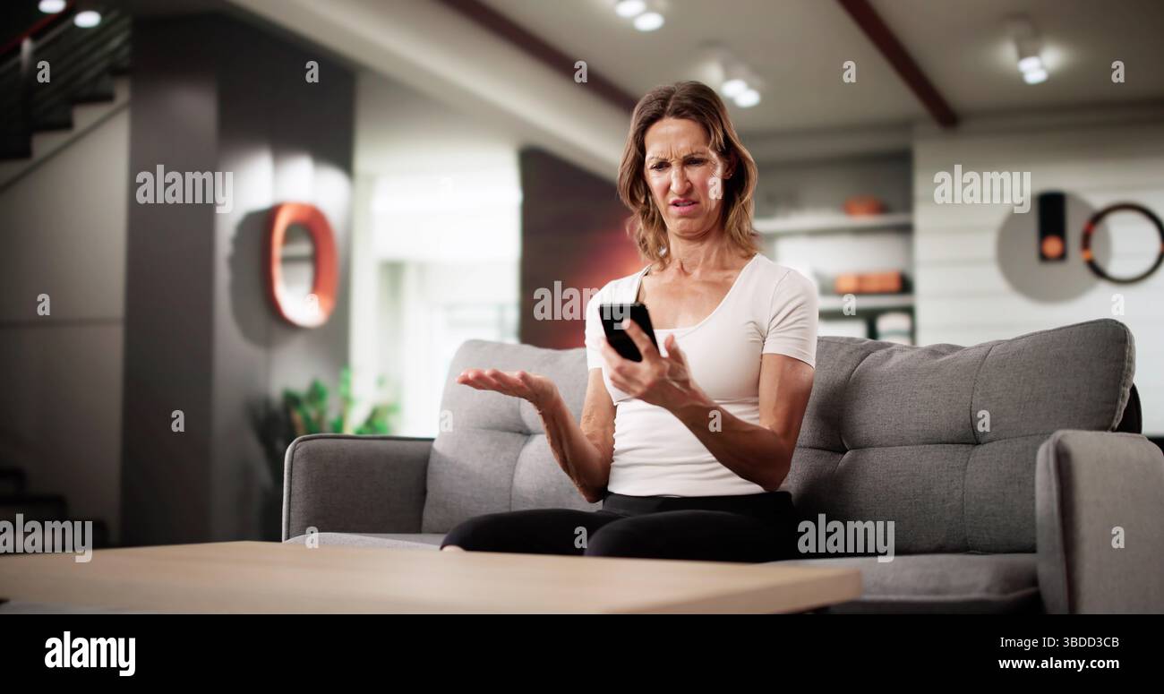 Mauvaise posture et erreur financière : femme avec douleur au cou utilise téléphone Banque D'Images