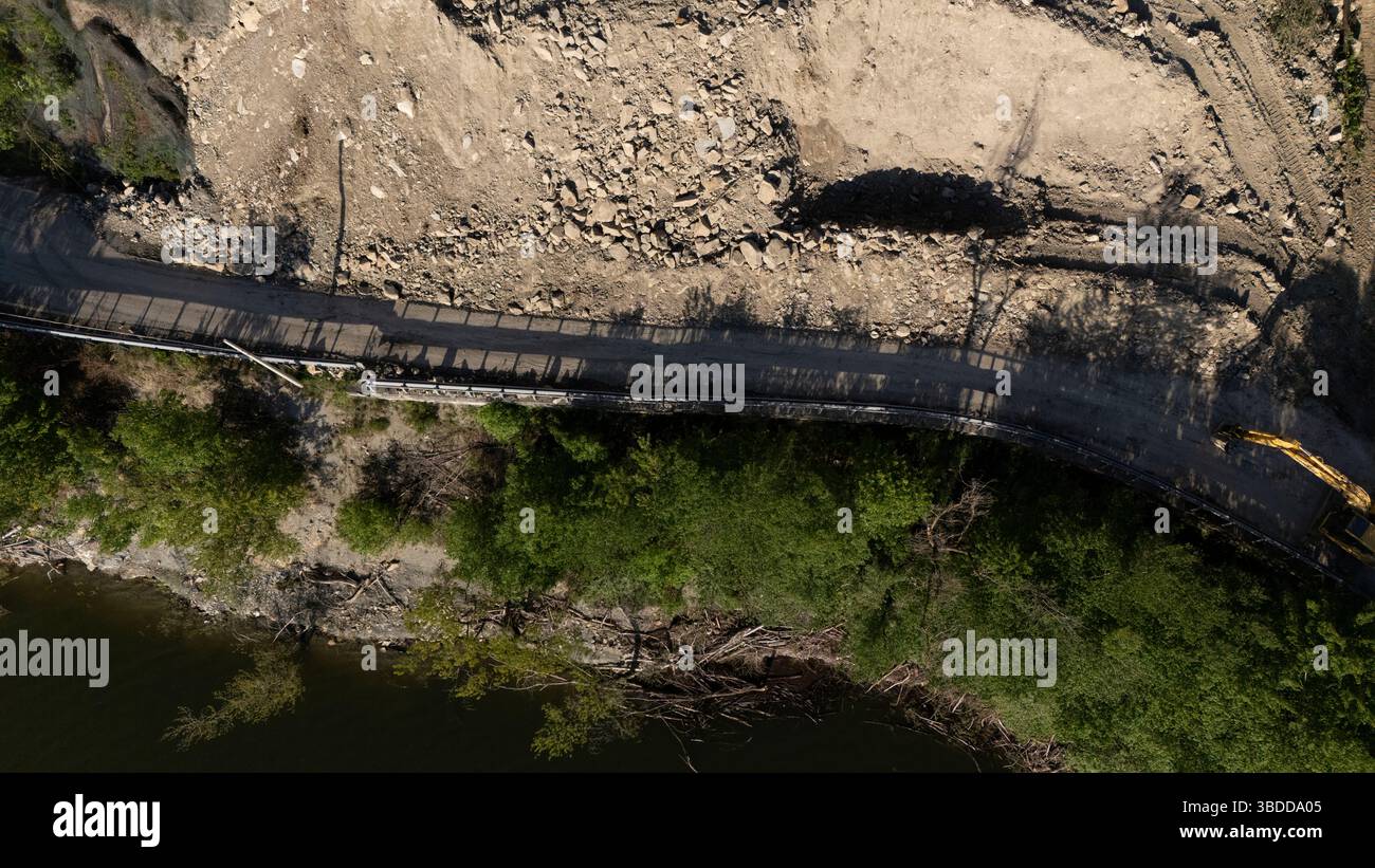 Mignano, Italie - 22 avril 2025 glissement de rocher sur la route provinciale Vernasca SP21 au-dessus des machines de construction du barrage de Mignano enlevant les grosses pierres et la saleté Banque D'Images