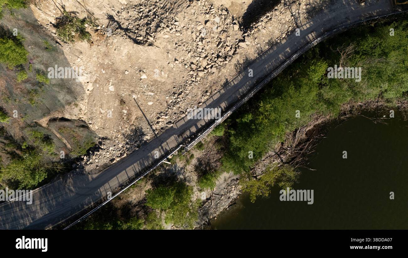 Mignano, Italie - 22 avril 2025 glissement de rocher sur la route provinciale Vernasca SP21 au-dessus des machines de construction du barrage de Mignano enlevant les grosses pierres et la saleté Banque D'Images