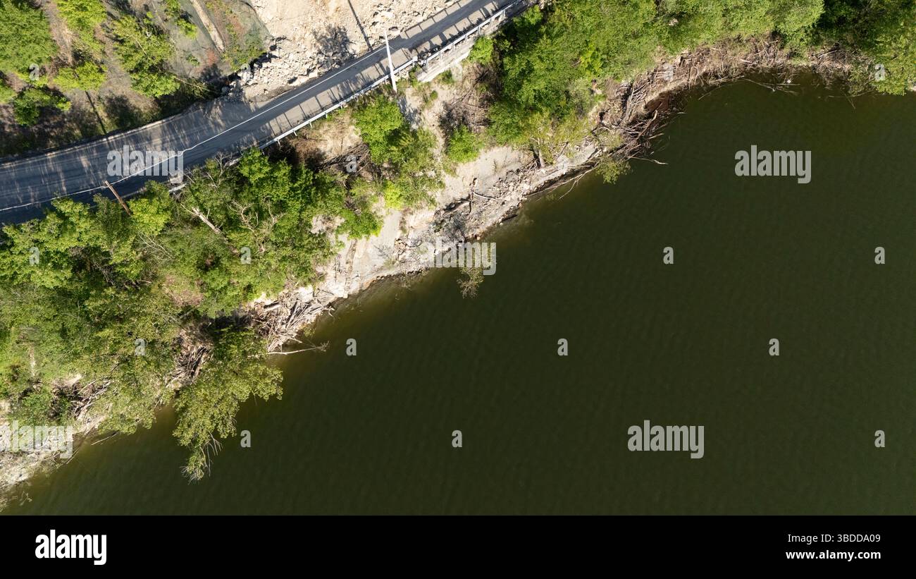 Mignano, Italie - 22 avril 2025 glissement de rocher sur la route provinciale Vernasca SP21 au-dessus des machines de construction du barrage de Mignano enlevant les grosses pierres et la saleté Banque D'Images