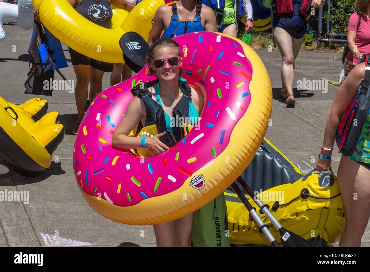 The Big Float, Portland, Oregon - 14 juillet 2018 : une femme sourit, prête à flotter sur la rivière Willamette avec d'autres sur des radeaux gonflables. Banque D'Images