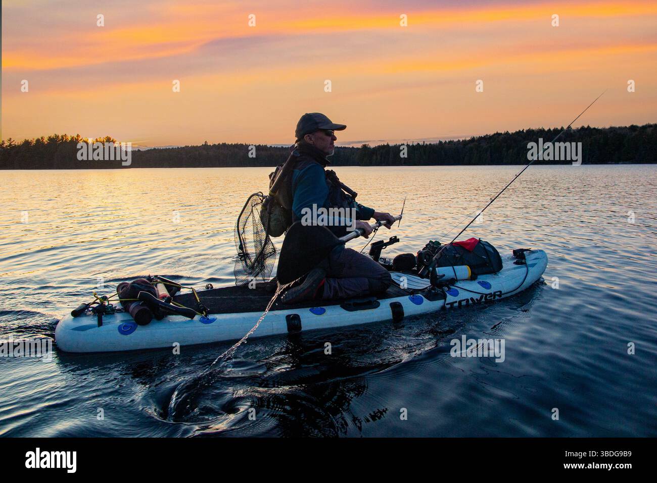 Un pêcheur pêche à l'aide d'un stand up Paddleboard (SUP) dans un lac du parc national Algonquin, Onario, Canada Banque D'Images