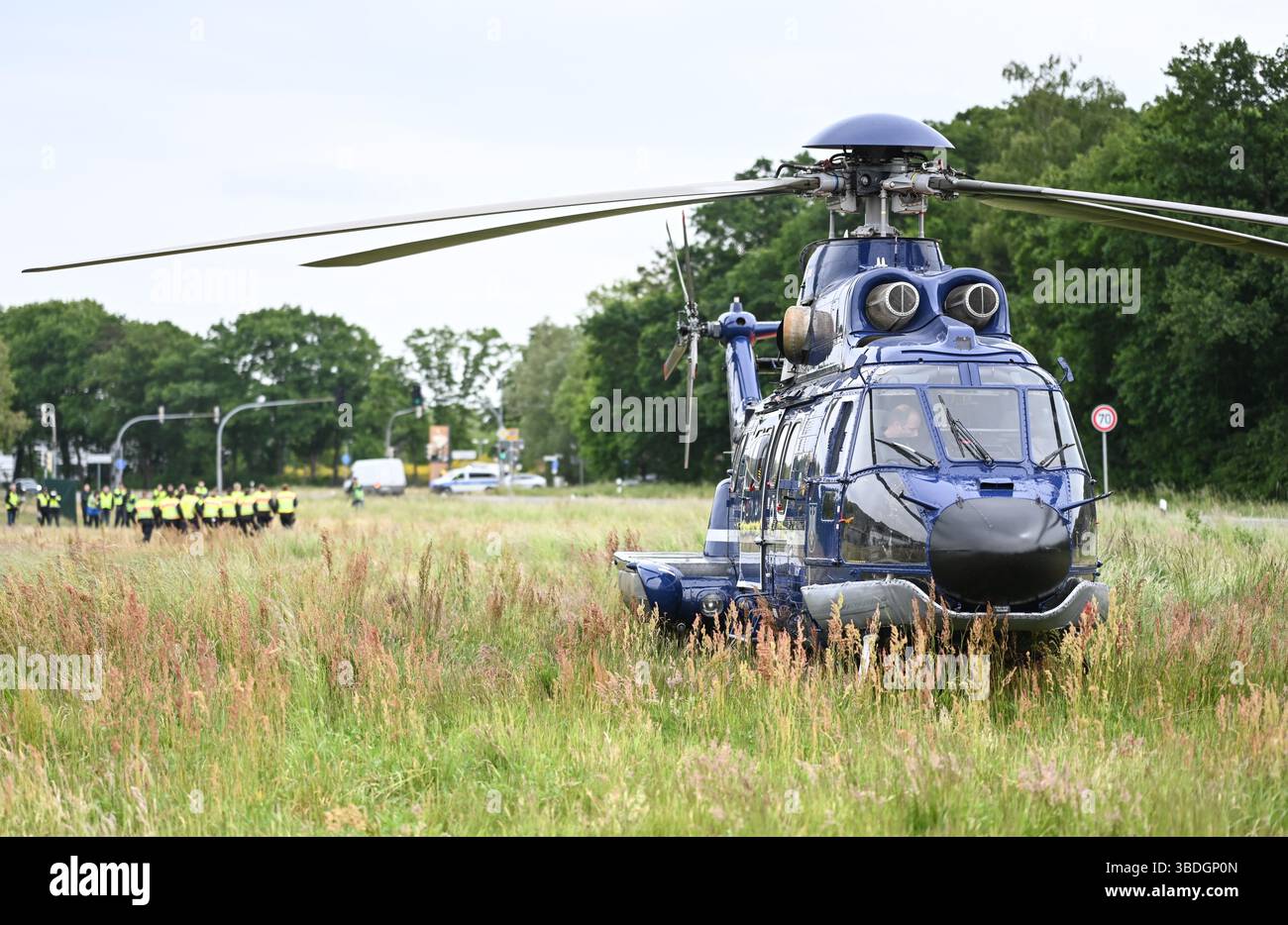 Nordhorn, Allemagne. 24 mai 2025. Les services d'urgence se rendent à un point de contrôle temporaire sur la route fédérale B213 après avoir été déposés par un hélicoptère de police. L'opération prioritaire a lieu dans le cadre du rétablissement temporaire des contrôles aux frontières intérieures le long de la frontière entre la basse-Saxe et les pays-Bas. Crédit : Lars Penning/dpa/Alamy Live News Banque D'Images