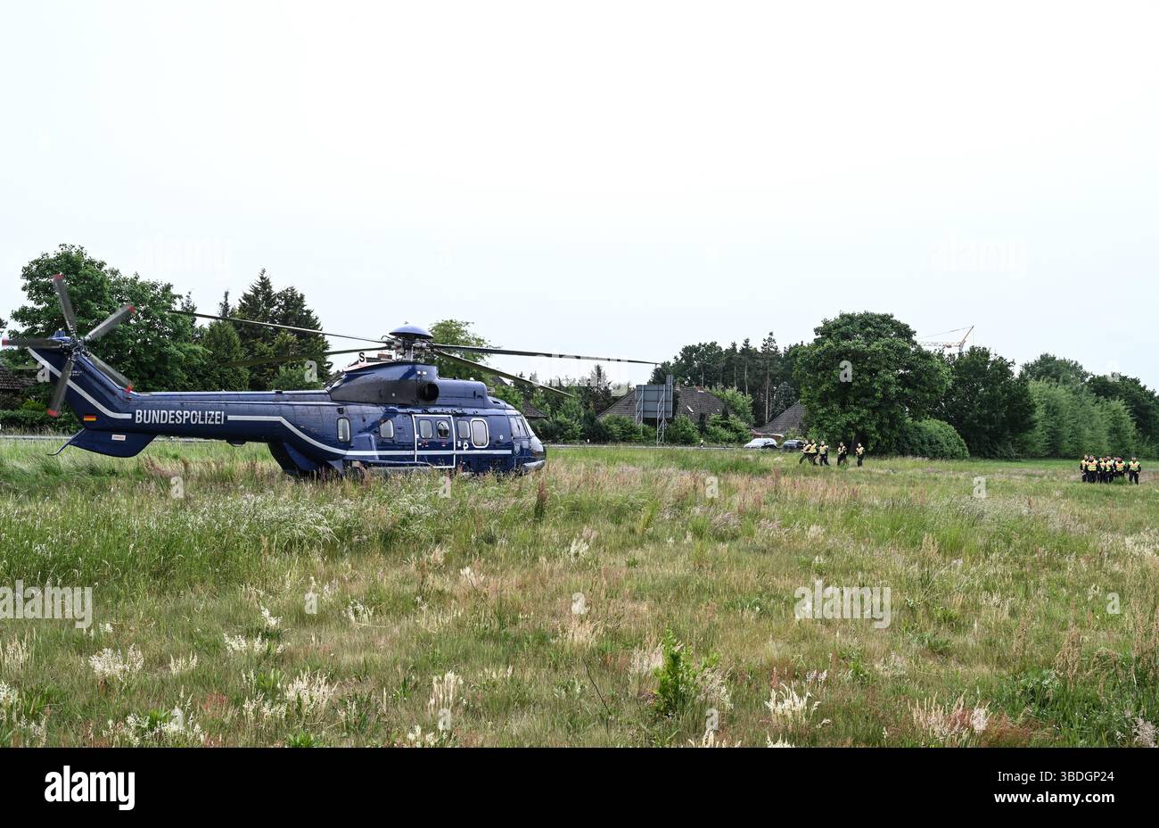 Nordhorn, Allemagne. 24 mai 2025. Un hélicoptère de police attend sur la route fédérale 213 (B213) les forces de police fédérales. L'opération prioritaire a lieu dans le cadre du rétablissement temporaire des contrôles aux frontières intérieures le long de la frontière entre la basse-Saxe et les pays-Bas. Crédit : Lars Penning/dpa/Alamy Live News Banque D'Images