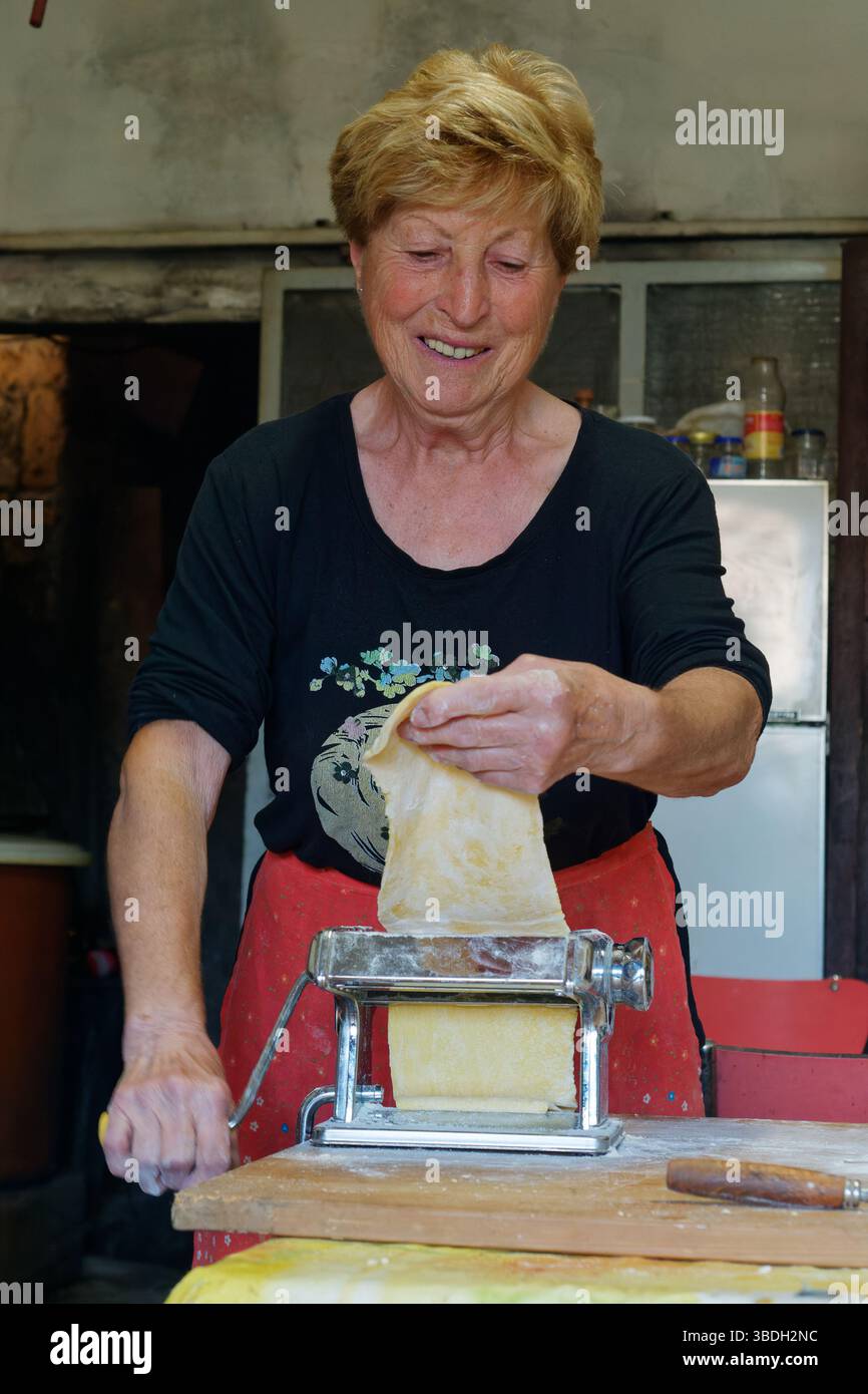 Une femme italienne sourit fièrement alors qu’elle fabrique des feuilles de pâtes pour le festival de la ricotta (Sagra di ricotta) à Montefiascone, Latium, Italie. 24 mai 2025 Banque D'Images