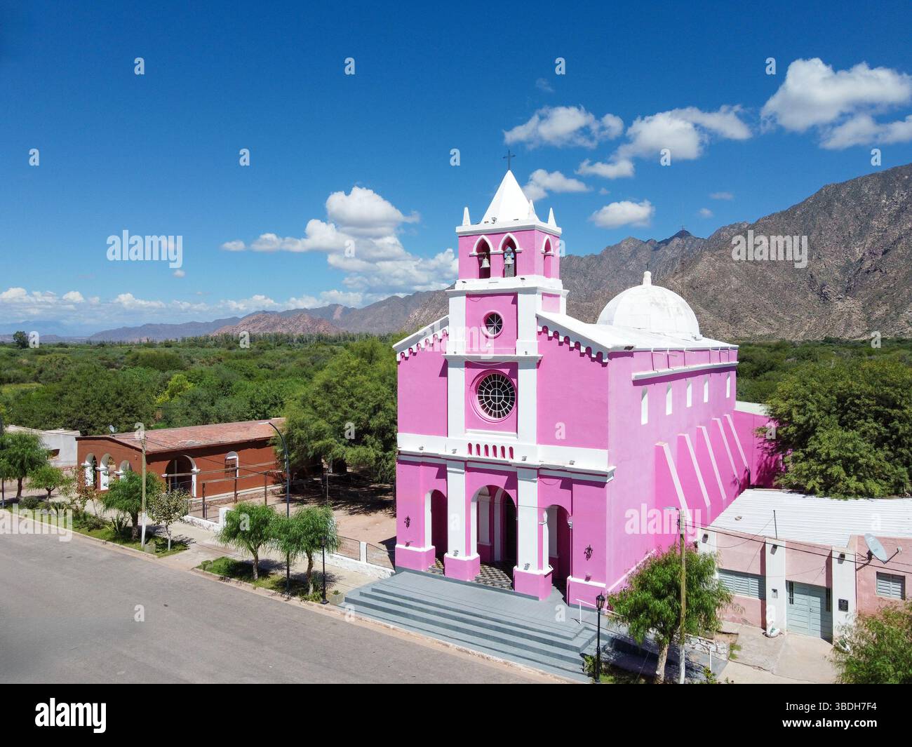L'église notre-Dame de Candelaria à Copacabana, Tinogasta, un havre de paix avec sa façade rose sous le vaste ciel bleu, encadrée par l'im de Catamarca Banque D'Images