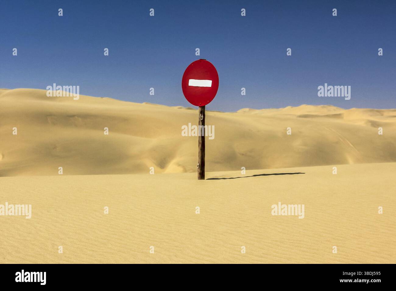 Panneau d'avertissement rouge dans le désert namibien avec des dunes de sable en arrière-plan Banque D'Images Panneau d'avertissement rouge dans le désert namibien avec des dunes de sable en arrière-plan Banque D'Images