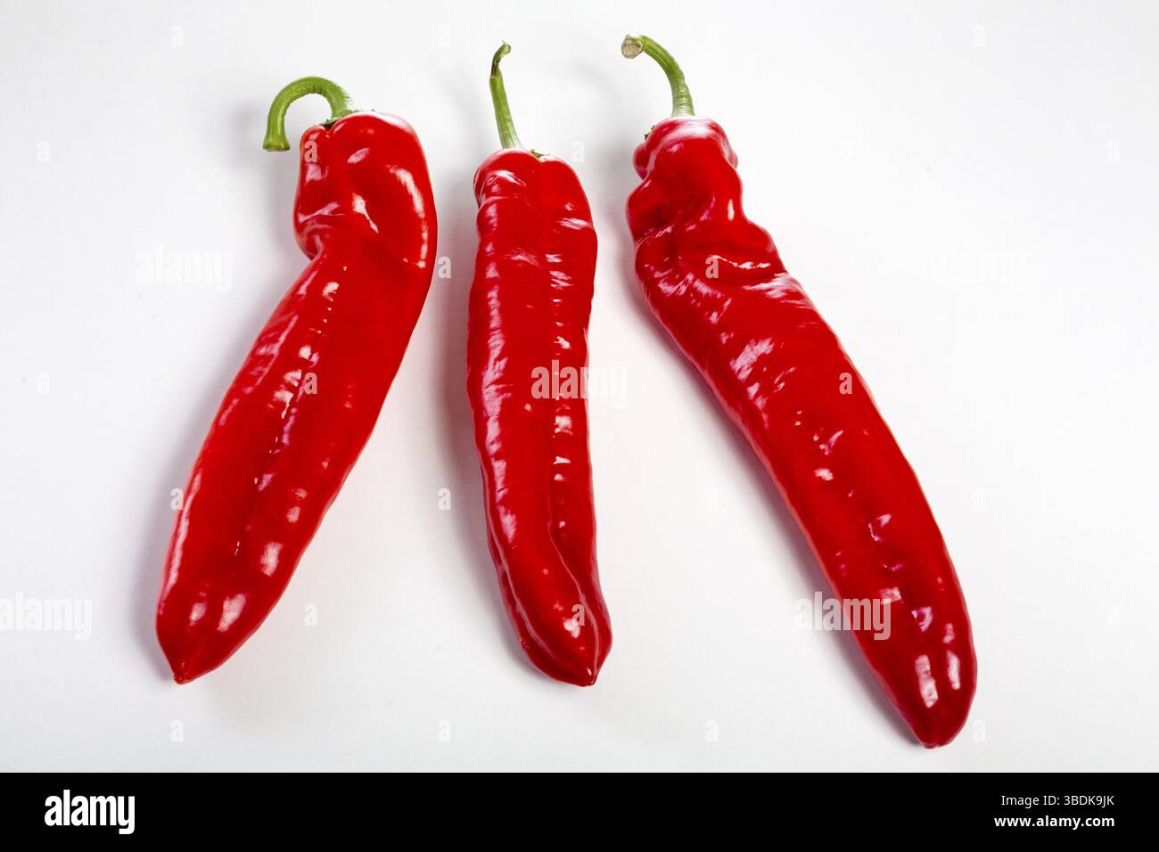 Un groupe de poivrons rouges sur fond blanc Banque D'Images