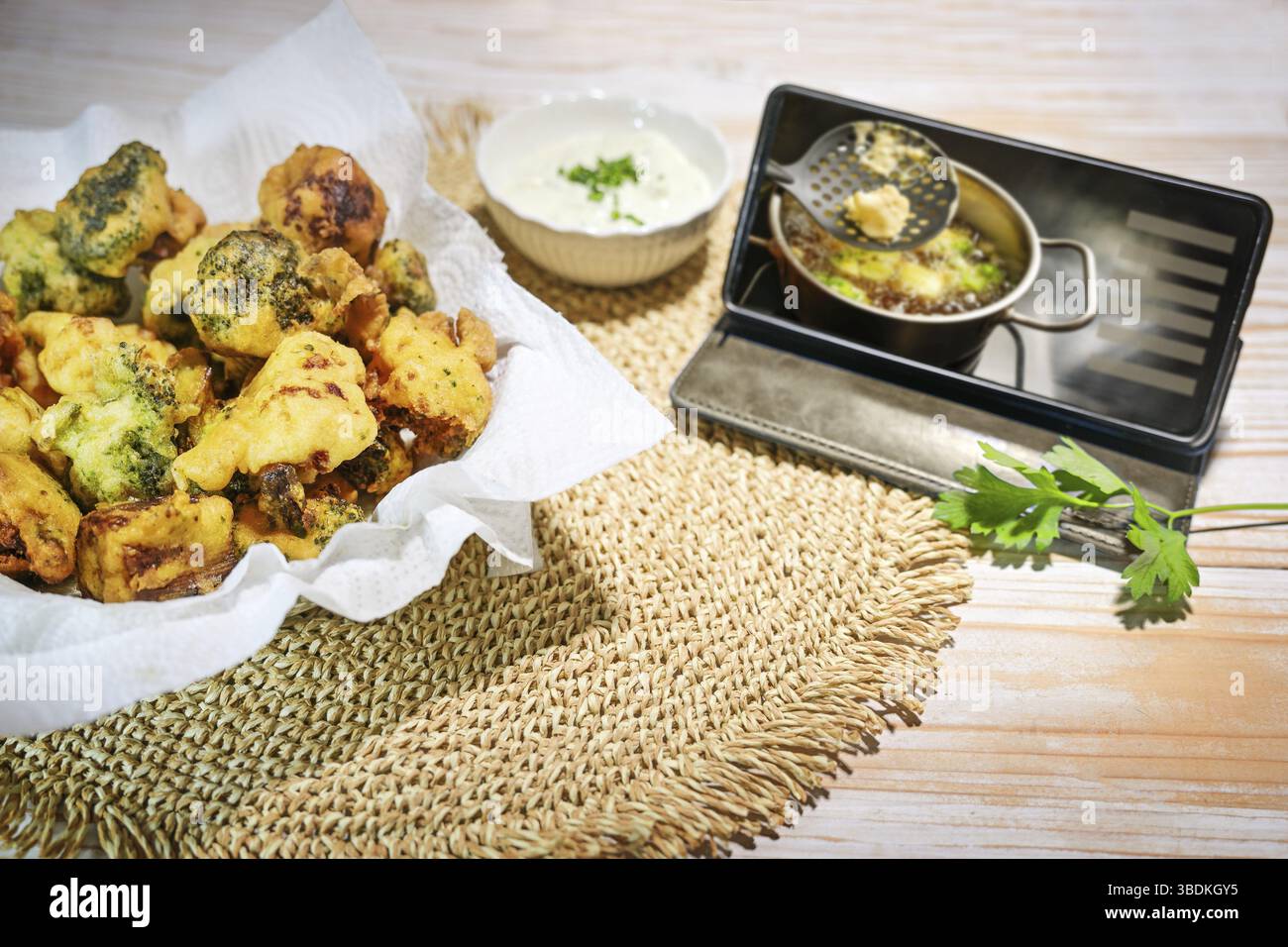 Chou-fleur frit et brocoli dans une pâte à bière prête à manger sur une table en bois et un smartphone montrant comment cuisiner la recette, copier l'espace, sélectionner Banque D'Images