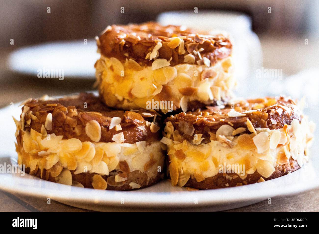 Gros plan de trois savoureux gâteaux appelés Bienenstich en allemand. Gâteau dessert fait d'une pâte à levure sucrée avec une garniture cuite d'amandes caramélisées. Banque D'Images