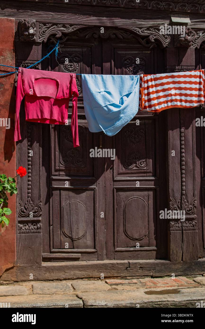 Népal : vêtements traînant à sécher devant une porte à Bhaktapur, ville dans le coin est de la vallée de Katmandou célèbre pour sa tradition Newar, cuisine Banque D'Images