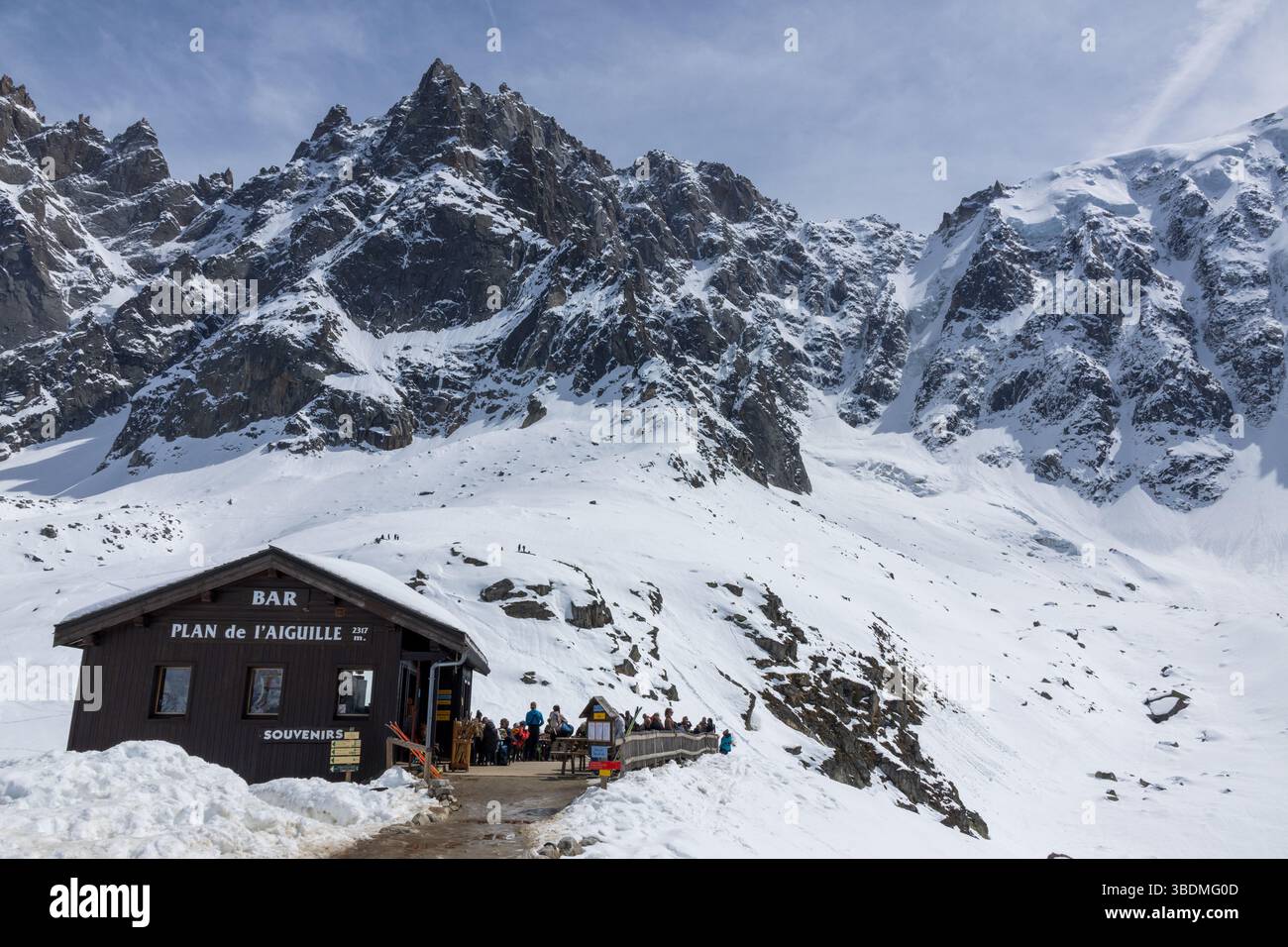 Les gens se détendent au bar Plan de l'aiguille au-dessus de la ville alpine française de Chamonix, avec des paysages de montagne spectaculaires en arrière-plan. Banque D'Images