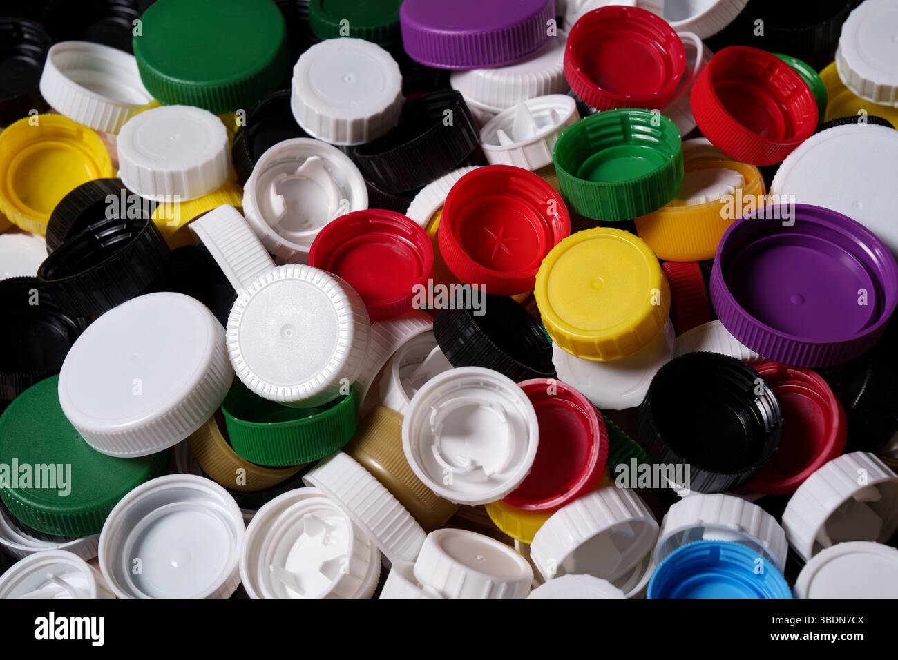Beaucoup de bouchons de bouteille en plastique coloré. Recyclage du plastique. Banque D'Images