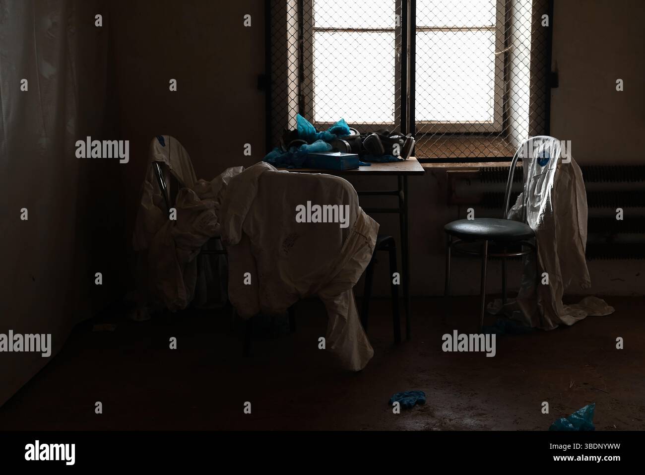 une pièce abandonnée vide avec des chaises, une table, des masques à gaz et des gants en caoutchouc - concept de production illégale de drogues Banque D'Images