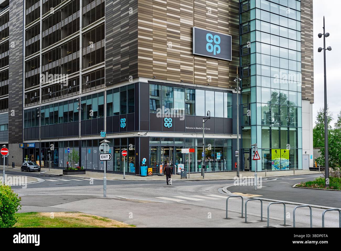 Salford, Manchester, Royaume-Uni, 05-24-2025 : magasin Coop. Vue sur la rue moderne et coin du bâtiment contemporain à façade vitrée. Banque D'Images