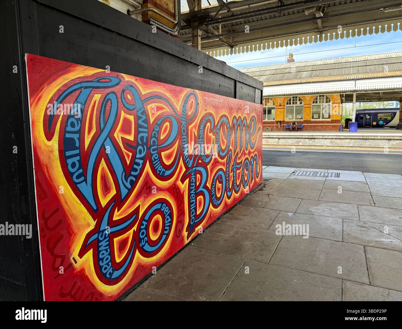 Panneau coloré disant « Bienvenue à Bolton » en plusieurs langues à la gare de Bolton - Image de stock capturée avec un smartphone