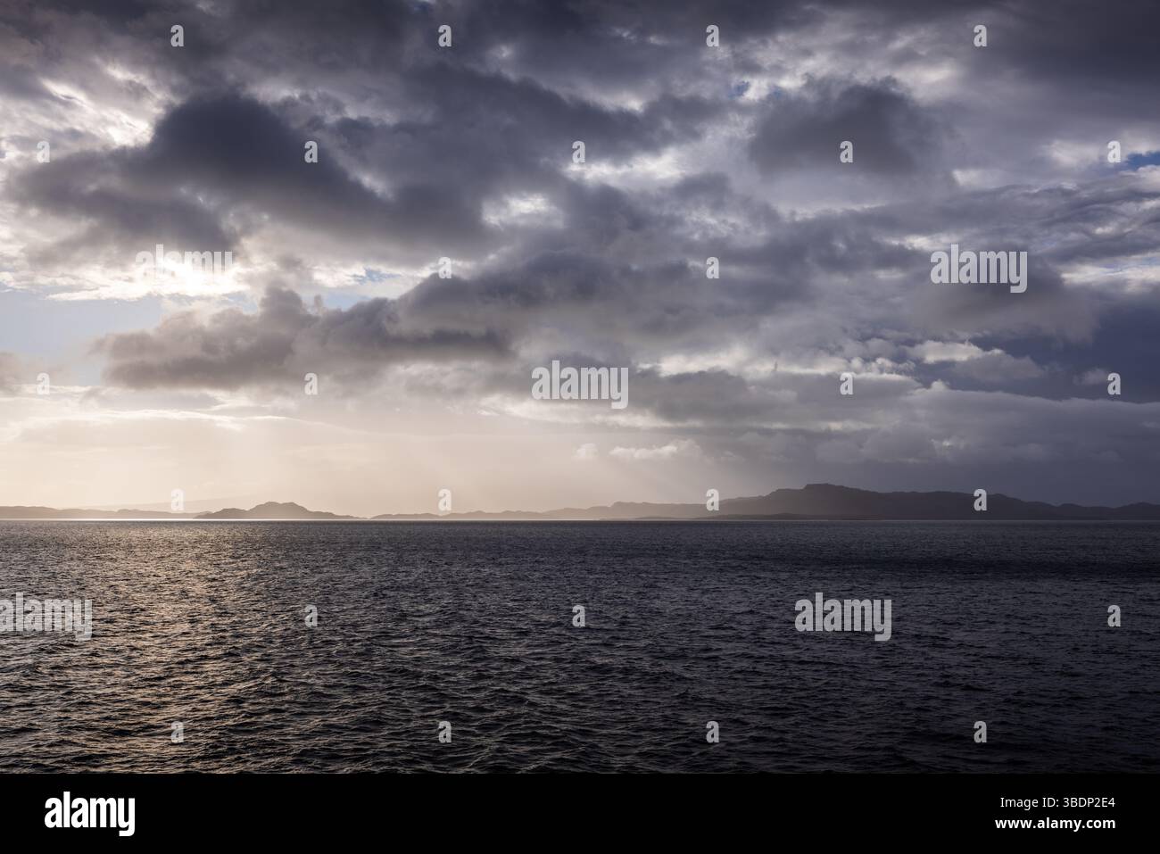 Ciel orageux au-dessus de l'Atlantique avec des rayons lumineux traversant les nuages et les îles silhouettes près de l'île de Skye, en Écosse. Banque D'Images Ciel orageux au-dessus de l'Atlantique avec des rayons lumineux traversant les nuages et les îles silhouettes près de l'île de Skye, en Écosse. Banque D'Images