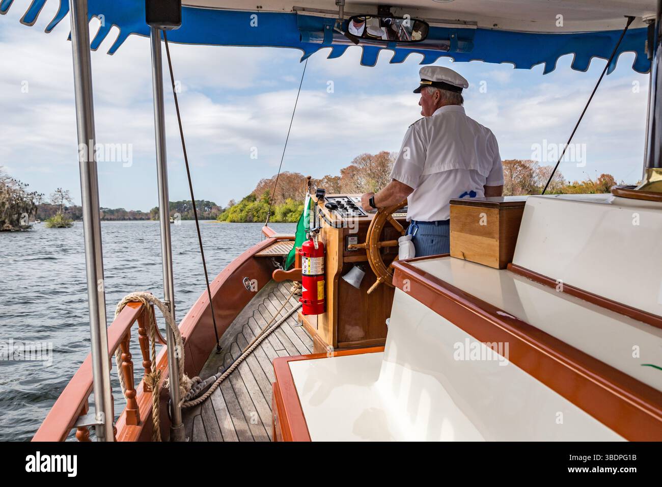 Le capitaine de bateau dirige un bateau touristique à travers Lake Buena Vista vers le Magic Kingdom à Walt Disney World, Orlando, Floride Banque D'Images
