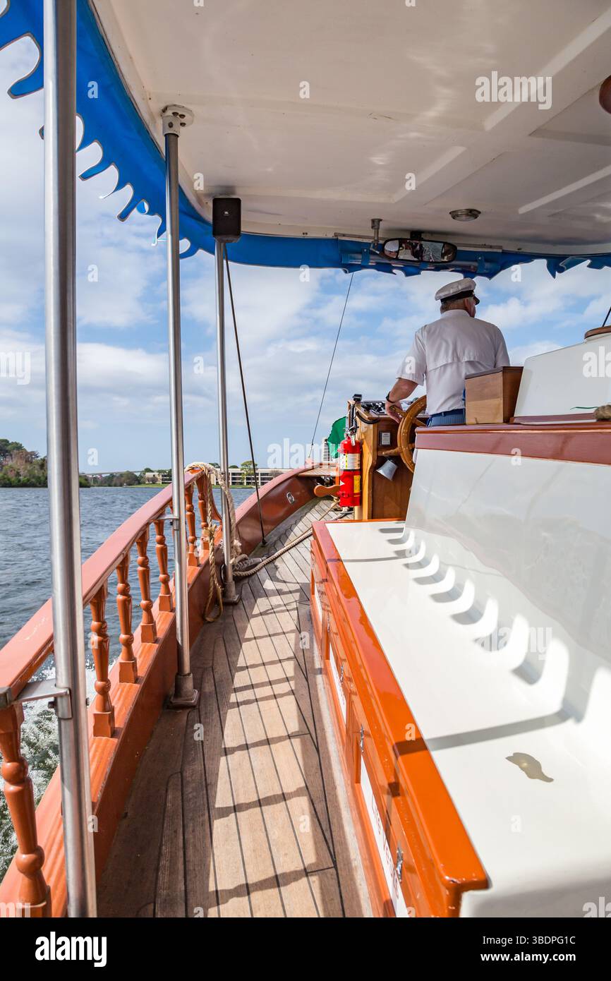 Le capitaine de bateau dirige un bateau touristique à travers Lake Buena Vista vers le Magic Kingdom à Walt Disney World, Orlando, Floride Banque D'Images